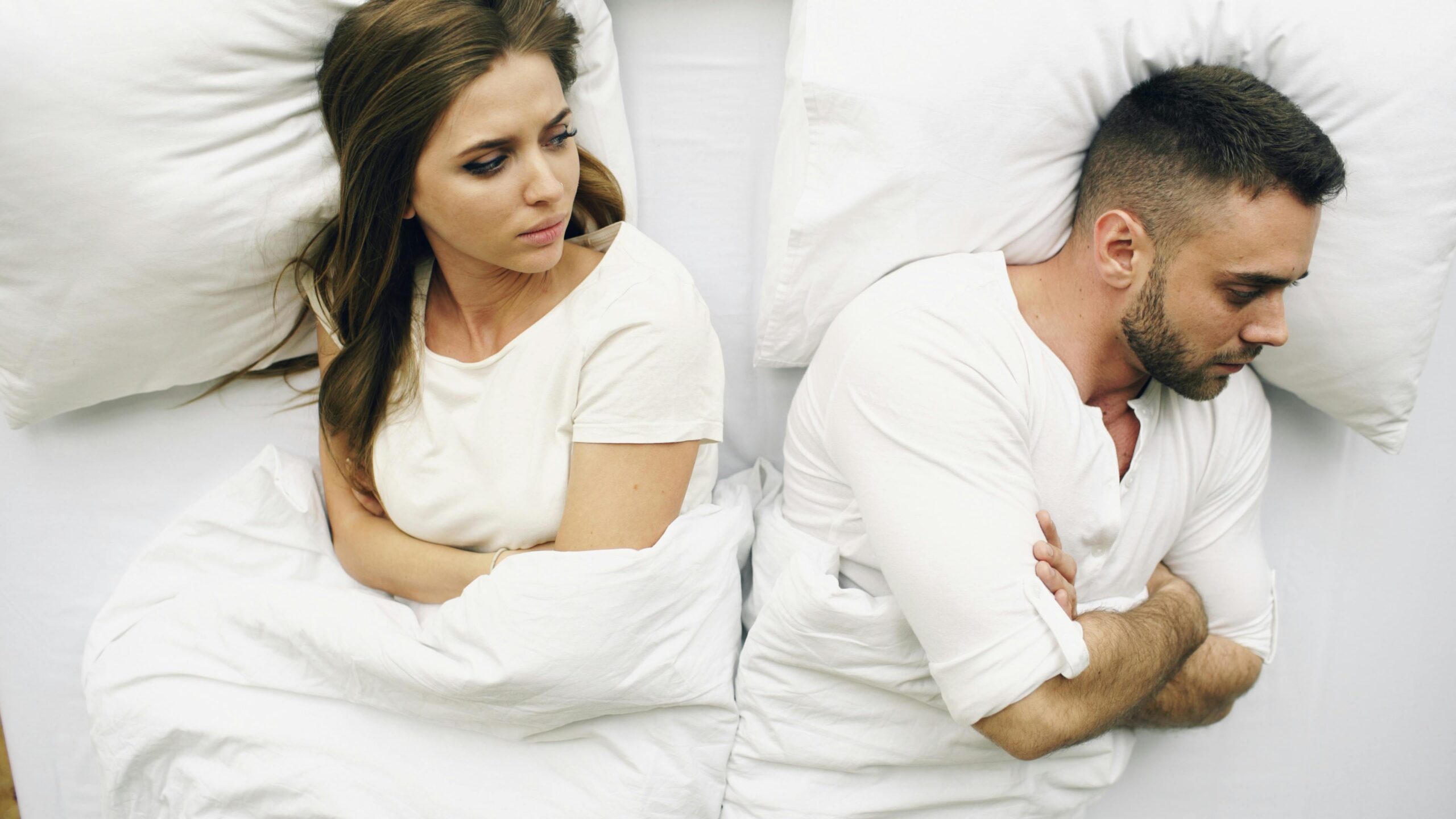 service-1 A couple in bed, facing away with tense expressions, suggesting conflict.
